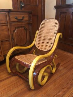 a wooden rocking chair sitting on top of a hard wood floor next to a dresser