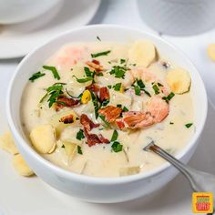 a bowl of soup with shrimp, potatoes and bacon