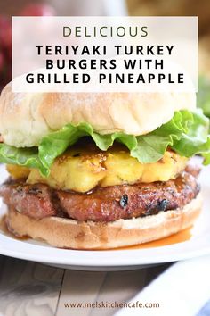 a hamburger with lettuce, cheese and other toppings on a white plate that says delicious teriyaki turkey burgers with grilled pineapple