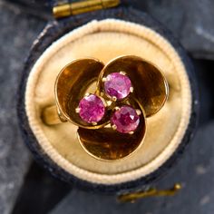 This reflective vintage ruby ring is centered with three round rubies that are prong set into the center of three patinated leaf motifs.  The ring is crafted in unpolished 14k yellow gold with a great soft color.  It is currently a size 6. Vintage Yellow Gold Ruby Birthstone Ring, Vintage Yellow Gold Ruby Ring Birthstone, Three Stone Ruby Ring In 14k Yellow Gold, Gold Ruby Ring With Three Stones, Vintage Gold Ruby Ring With Three Stones, Vintage Three-stone Ruby Ring Gift, Vintage Three Stone Ruby Ring Gift, Three Stone Ruby Ring In Yellow Gold, Vintage Yellow Gold Three Stone Ruby Ring