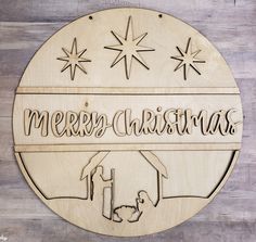 a wooden sign that says merry christmas with a nativity scene in the center and stars above it