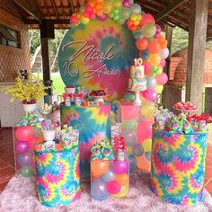 there are many colorful cakes and balloons on the table