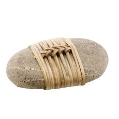 a close up of a rock with a woven bracelet on it