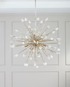 a chandelier hanging from the ceiling in a room with white walls and doors