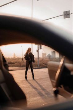 a woman walking across a street next to a traffic light