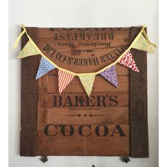 a wooden sign that says baker's cocoa and bunting with flags on it