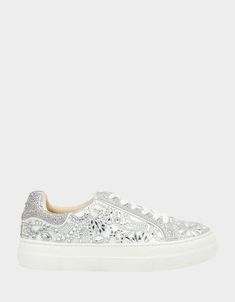 a woman's white sneaker with sequins on the side and lace detailing