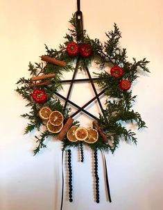 a star made out of oranges and cinnamons hanging on a wall with other decorations