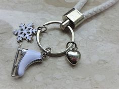 a keychain with two charms on it and a snowflake in the background