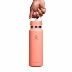 a hand is holding the lid on a pink water bottle that's in front of a white background