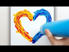 someone is painting a heart with blue and yellow paint