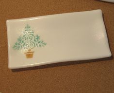 a white plate with a green christmas tree on it