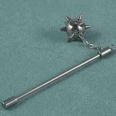 a metal object with spikes attached to it on a blue carpeted surface and two other items in the background