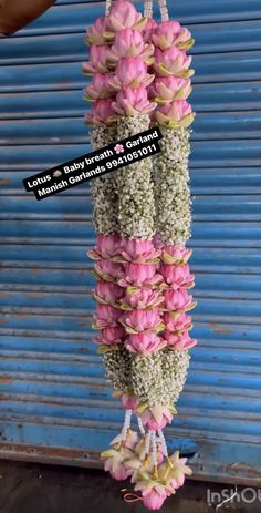 pink and white flowers hanging from a blue door