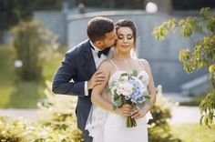 a bride and groom embracing each other outside