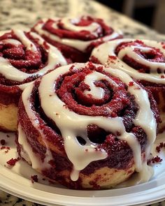 a white plate topped with pastries covered in icing on top of a table