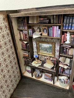 an old bookcase with many books in it and a painting on the wall behind it