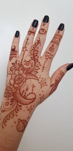 a woman's hand with henna tattoos on it