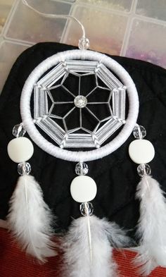 a white and black dream catcher sitting on top of a table