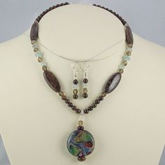 "This is one of my favorite Lampwork Pendants.  The lucky buyer will not believe the subtle organic play of the colors in this eye catching double-sided work of art.  I used my best Aqua and Smoky Quartz beads with the rich irridescent browns of the Bronzite Jasper.  Necklace length is 18\". The matching earrings are included. Each of my beaded pieces is a unique one-of-a-kind creation with it's own special character setting it apart from any other beaded piece. All metal is Sterling Silver in my beaded jewelry unless otherwise specified.  *There is no charge for shortening necklaces. Ask for options if you need lengthening. Betty" Nature-inspired Multicolor Round Jewelry, Earthy Style Multicolor Round Jewelry, Earthy Multicolor Round Jewelry, Vintage Assemblage Necklace, Upcycled Vintage Jewelry, Lampwork Pendant, Vintage Assemblage, Assemblage Necklace, Horses Pendant