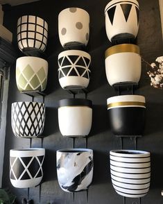 many white and black vases are hanging on the wall