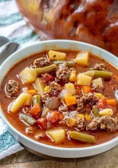 a white bowl filled with meat and vegetable soup