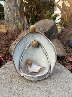 three ceramic bowls sitting on top of each other in front of some rocks and plants