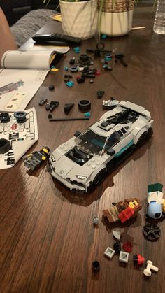 a toy car is laying on the table next to legos and other toys that have been placed around it