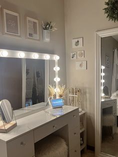 a bedroom with a vanity, mirror and lights