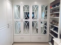 a walk in closet filled with lots of white shelves and shoes on top of them