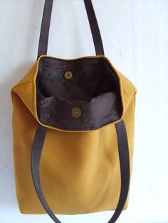 Mustard yellow large tote bag. Fall shoulder bag. Autumn tote. Exterior: * Mustard yellow cotton fabric. * Real letaher handles in chocolate brown. Reinforced with an antique brass rivets. Interior: * 100% unbleached cotton victorian print in chocolate brown * Closes with a magnetic snap closure. * Two interior pockets - one smaller for your mobile device, one largee for your bits. Large chic tote in gorgeous mustard yellow color. Approx. Measurement: * Height: 15.5 inches * Width: 13.inches * W Yellow Cotton Fabric, Mustard Yellow Color, Longchamp Le Pliage Backpack, Large Tote Bag, Mobile Device, Longchamp Le Pliage, Large Tote, Mustard Yellow, Yellow Color