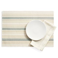 a plate and napkin on top of a striped placemat