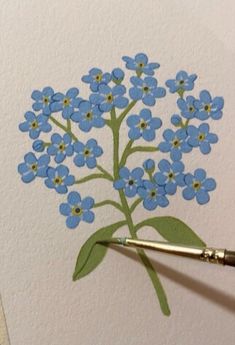 a blue flower with green leaves on it is being drawn by a person's hand