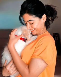 a woman holding a small white dog in her arms