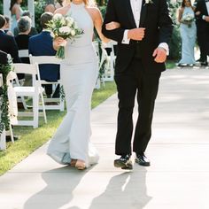 a bride and groom walking down the aisle