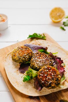 two meat patties on a tortilla with lettuce and garnish