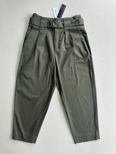 Elevate your wardrobe with these trendy Banana Republic pants. The pants are inspired by the 90s army theme and feature a cropped style with a wide baggy fit. The high-waisted pants are made of a comfortable blend of spandex and cotton twill fabric and come in a solid army green color. The pants have a pleated front and a zipper closure with accents that add a touch of modernity. Perfect for any occasion, these pants can be dressed up or down. The pants have a waist size of 28 inches and an inseam of 23 inches, making them a great fit for women's size 6. The pants are machine washable and were made in Sri Lanka. Add these stylish pants to your collection and make a statement with your fashion sense. Free returns & Fast shipping. Army Theme, Stylish Pants, Banana Republic Pants, Pants Womens, Cropped Style, Twill Fabric, Cotton Twill Fabric, Baggy Fits, Fashion Sense