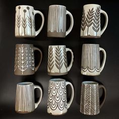 six coffee mugs with designs on them are lined up against a black background,