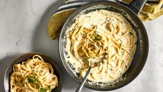 two bowls filled with pasta on top of a table