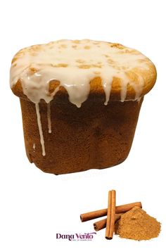 a muffin with icing and cinnamon sticks next to it on a white background