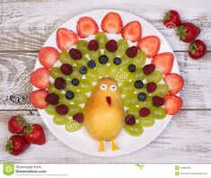 a white plate topped with grapes, strawberries and a turkey made out of fruit