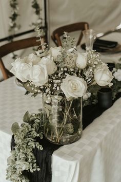 a vase filled with white flowers sitting on top of a table