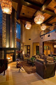 a living room filled with lots of furniture next to a fire place and chandelier