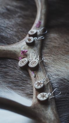 Small Handmade Earrings made of Reindeer Antler & Sterling Silver with engraved symbols. Four different options to choose from: Sunwheel, Wise Woman, Reindeer, Snow Crystal. Length of the antler part: Approx. 1,2cm Materials used: Reindeer antler & sterling silver *Reindeer naturally sheds their antlers yearly so no animals have been harmed to make these crafts. I get mine from a small village in Finnish Lapland called Sodankylä!  Tracked shipping inside of Finland. Elsewhere Standard shipping. Reindeer Antler Jewelry, Finnish Lapland, Antler Earrings, Antler Crafts, Antler Jewelry, Hardware Jewelry, Wise Woman, Snow Crystal, Reindeer Antlers