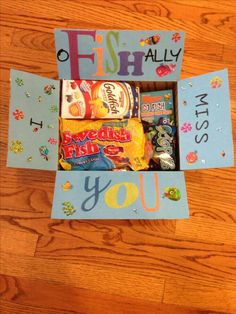 an open box filled with candy on top of a wooden floor next to a sign that says fish ally