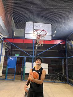 a man holding a basketball in front of a hoop