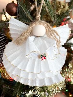 an angel ornament hanging from a christmas tree