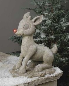 a small statue of a deer sitting on top of snow