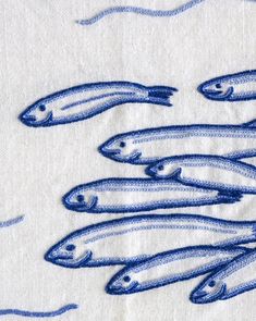 a group of fish on a white cloth with blue threading in the middle and bottom