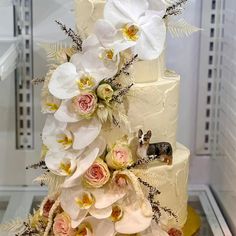 a three tiered cake with white flowers and a deer figurine